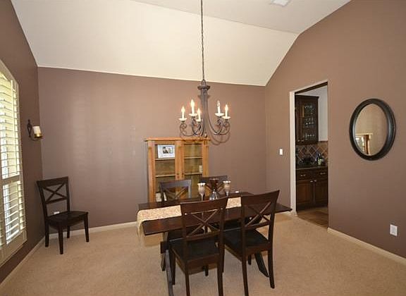 The dining room with a beveled ceiling can easily accommodate a