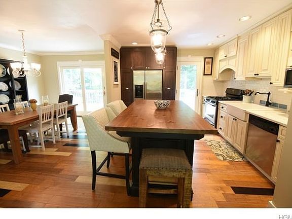 Gourmet kitchen with large island with seating, farm sink, stainless steel appliances and Silestone counter tops.