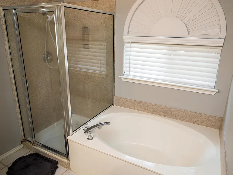 Private En-Suite Bathroom Featuring a Double Vanity, Garden Tub, and Separate Shower, Plus an Oversized Walk-In Closet