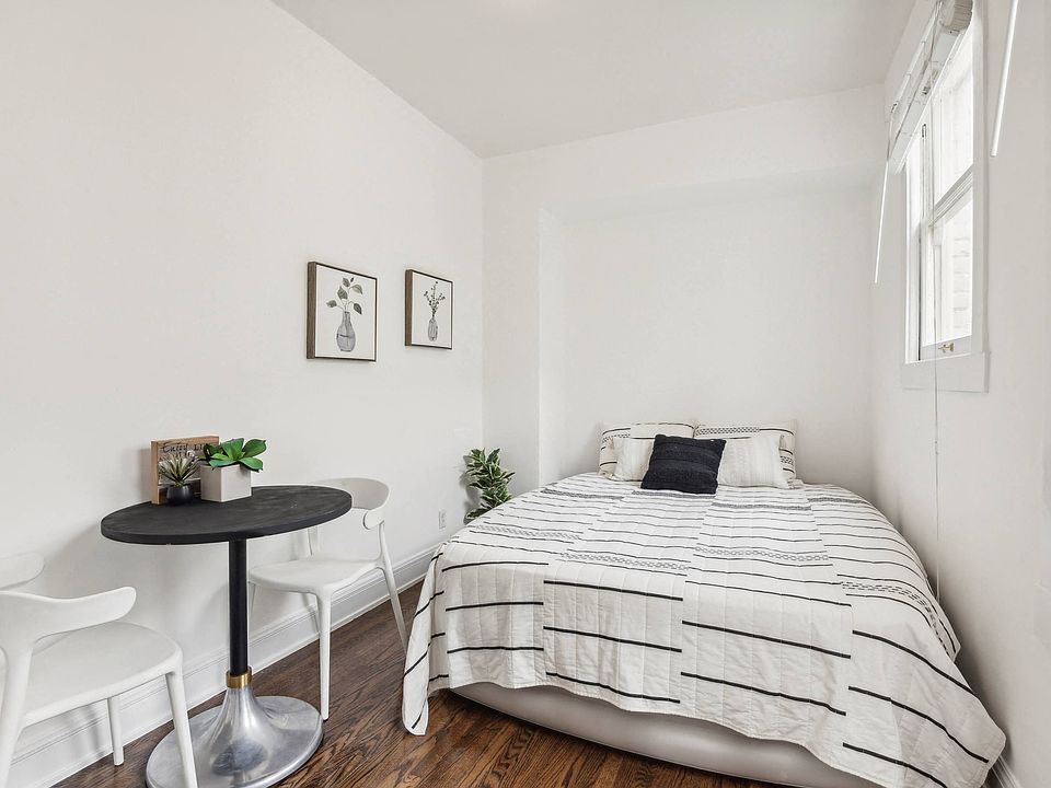 Bedroom with bed, comforter, pillows, and a small table with chairs