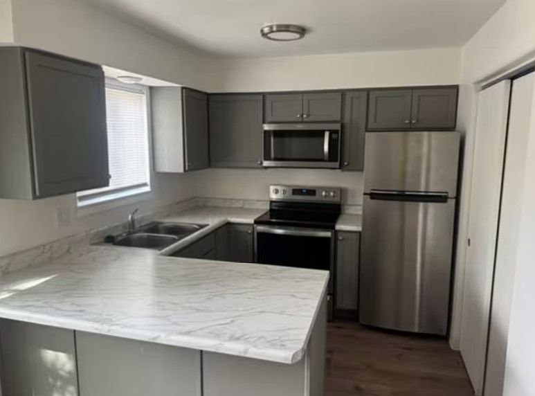 Updated kitchen with microwave, refrigerator, and stove.