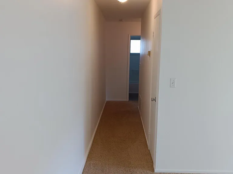 Hallway from living room to main bathroom and the 2 bedrooms.