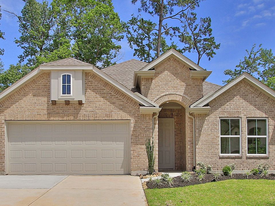 Experience refined elegance in this brick residence featuring an arched entryway and lush landscapin