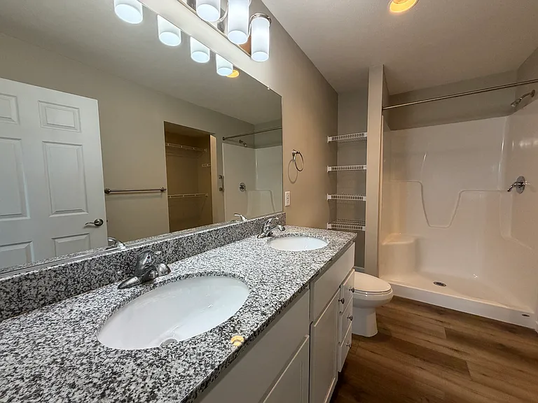 Primary bathroom features granite countertop with dual sinks