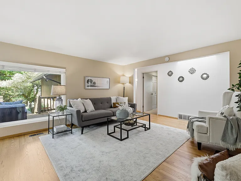 Light-filled living room with large picture window overlooking the yard