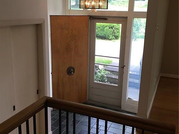 Step inside to dramatic sunlit foyer.  Note super cool front door- with centered door handle!