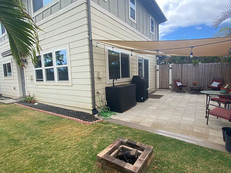 Side yard w/ fire pit and outdoor sink (grill and furniture pictured are no longer present)
