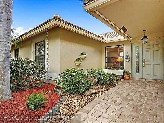 Wide, covered, paver entry with garden and bubbly fountain.  Front of house has impact windows and steel front door.