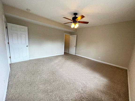 Large Primary Bedroom with ceiling fan and walk-in closet.