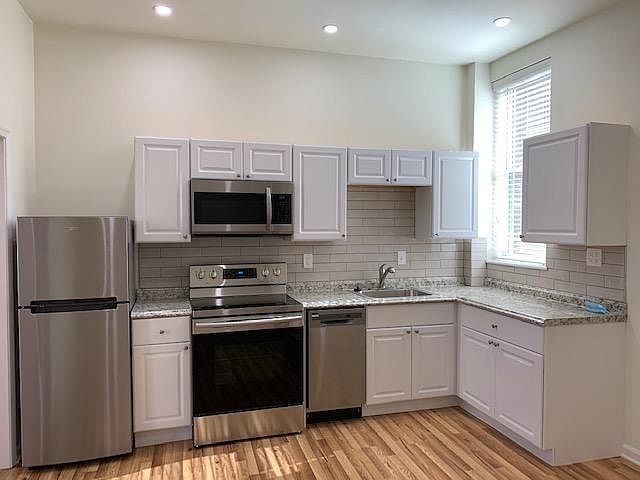 Kitchen Area with Stainless Steel Appliances; Refrigerator, Range/Oven; Microwave, Dishwasher; Sink/Garbage Disposal; Porcelain Tile Back Splash; White Cabinets; LED Dimmer Controlled Ceiling Lighting