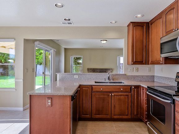 Beautiful updated kitchen with silestone countertops, tile flooring, and stainless steel appliances.