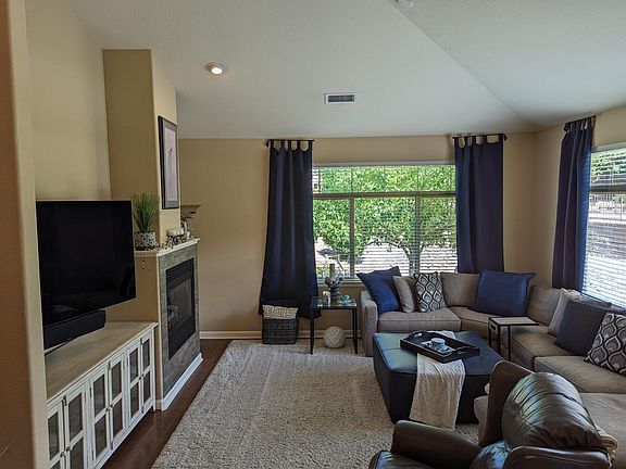 Large front livingroom with vaulted ceiling and cozy gas fireplace. Large windows