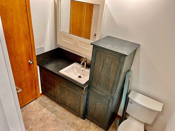 Primary bath on the main level is shared by the two bedrooms. This room is completely re-done with custom built sink and storage cabinets as well as a mirrored vanity with even more storage.