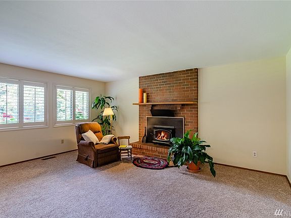 Cozy fire place with beautiful picture windows to see the flower window boxes outside.