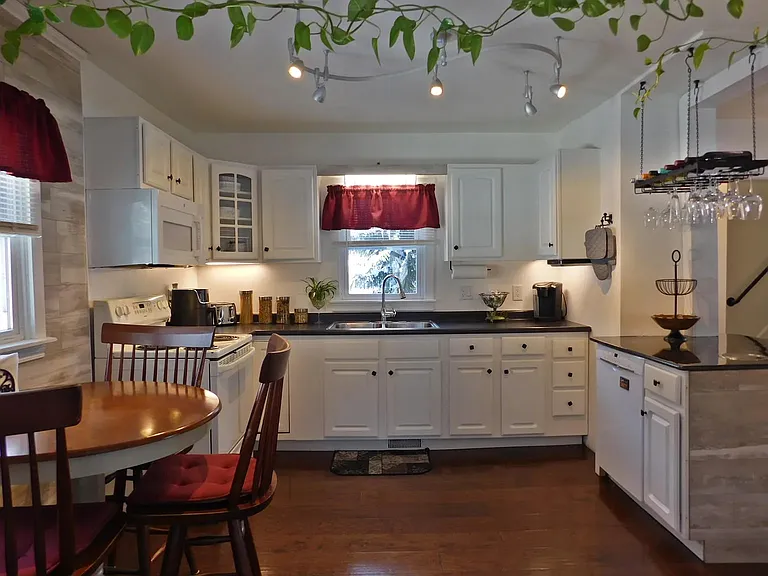 Full kitchen with microwave, oven, air fryer, fridge, and dishwasher, as well as basic appliances and dishware.