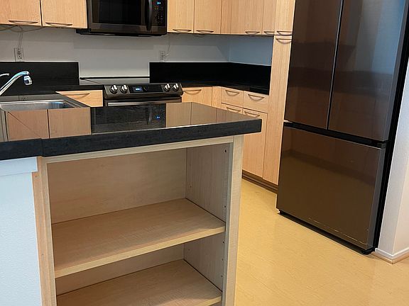 Kitchen view, double door Samsung smart refrigerator. Convenient shelves for cookbooks, etc.