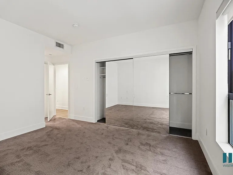 Bedroom with Mirrored Closet and Windows