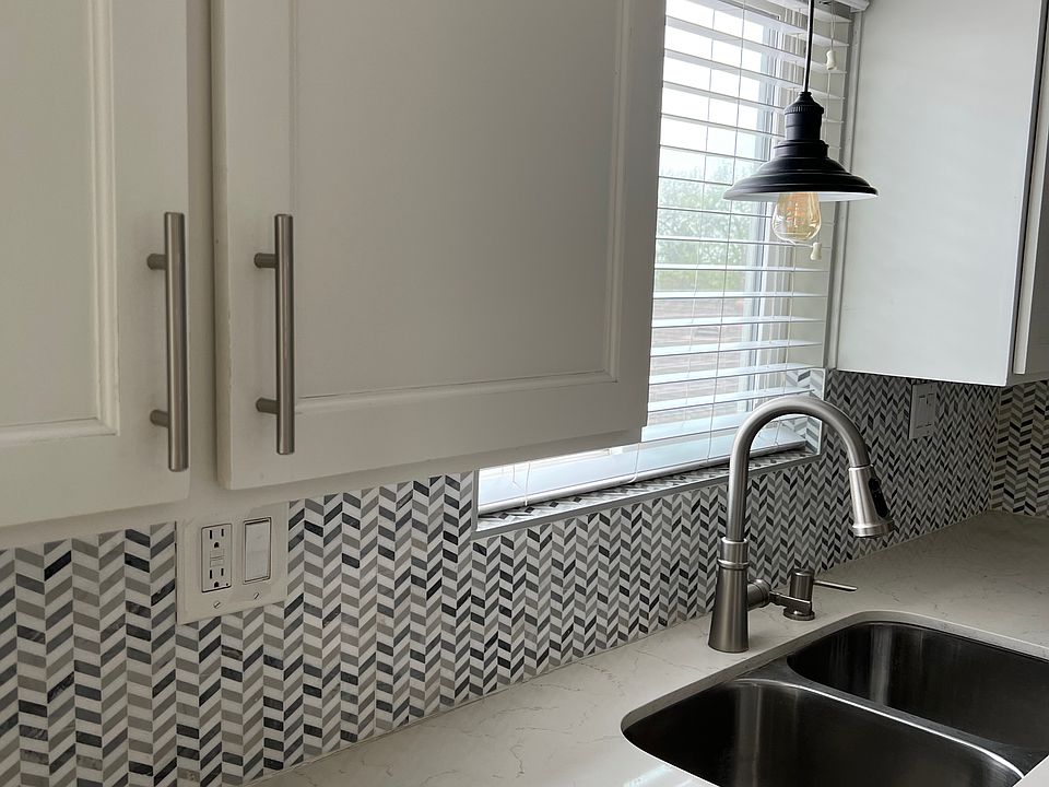 Beautiful kitchen with quartz countertops, beautiful backsplash and appliances.
