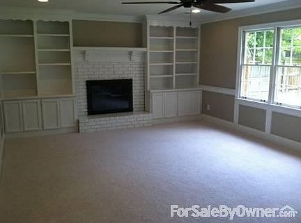 Den : Built-in shelves and cabinets with wood burning fireplace