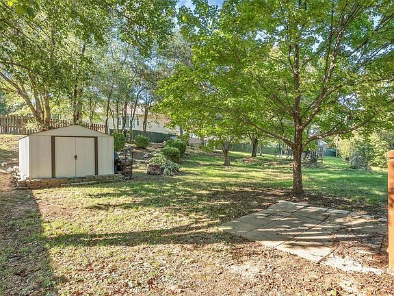 Private back yard with mature shade trees & shed.
