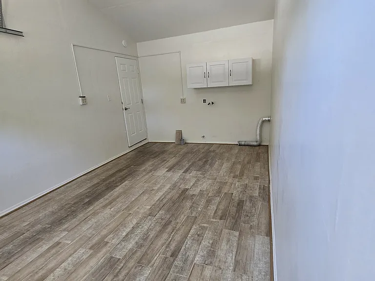 This view shows the high ceiling with ceiling fan, fire door and laundry area
