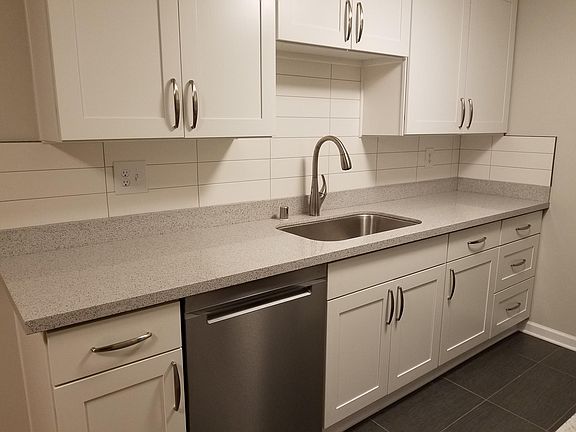 Quartz, matching stainless, white Shaker cabinets, ice maker, microwave and tile flooring for easy clean.