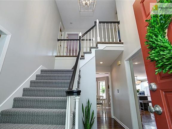 Gorgeous entry with new light fixture, gleaming floors and brand new stairway carpeting