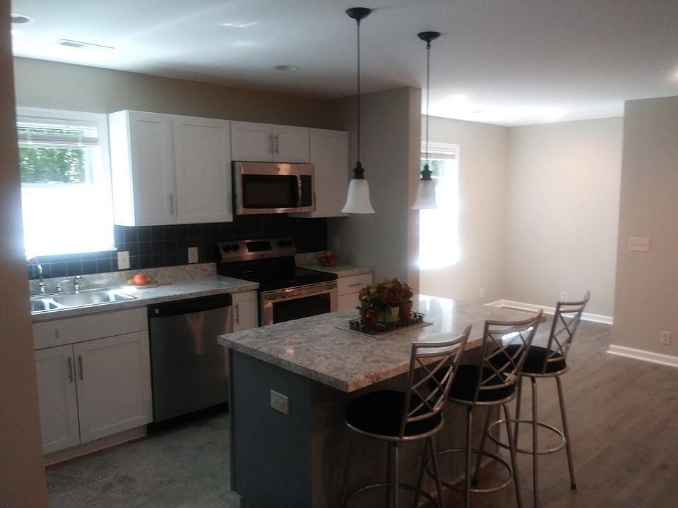 Kitchen with additional chef island and bar stools.