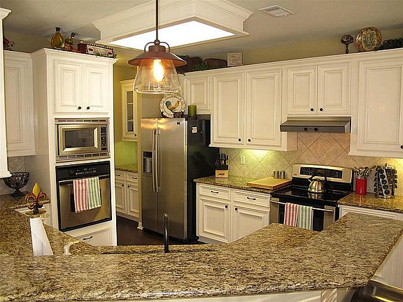 Gourmet kitchen boasts granite counters, stainless appliances and tile backsplash!