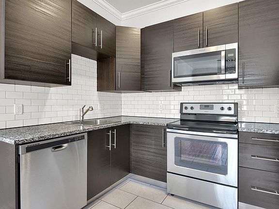 kitchen - level 1: granite countertops, stainless appliances, tiled backsplash, energy-efficient appliances, self-cleaning oven, crown molding, soft close cabinets