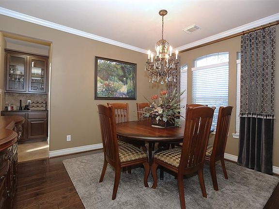 This dining room is spacious, with a gorgeous chandelier accenting the space.