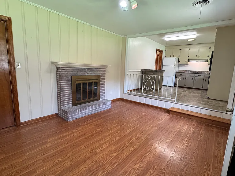 Family room. Door shown on left of picture opens to the garage. Fireplace is decorative.