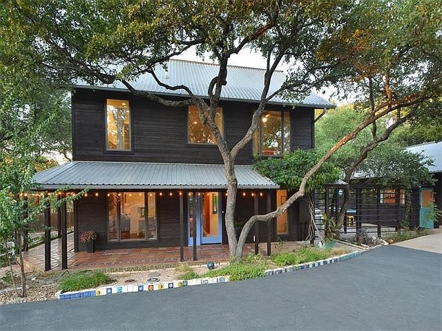 Large wrap-around patio leads to the front door of this McKinney York designed modern artisan retreat