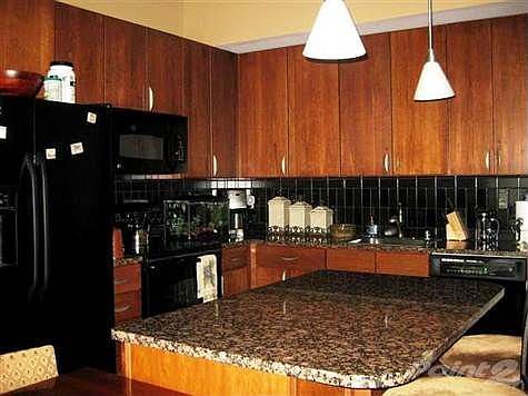Kitchen has upgraded granite countertops, black tile backsplash, black appliances, island to accommodate seating.