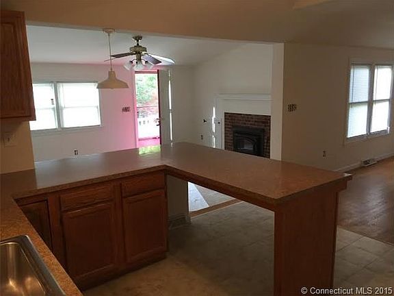 Kitchen is open to living room with fireplace and family room with hardwood flooring.