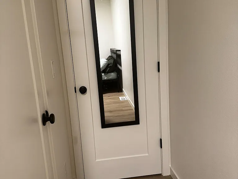 Entry hallway with new flooring and a full-length mirrorideal for quick checks before heading out.