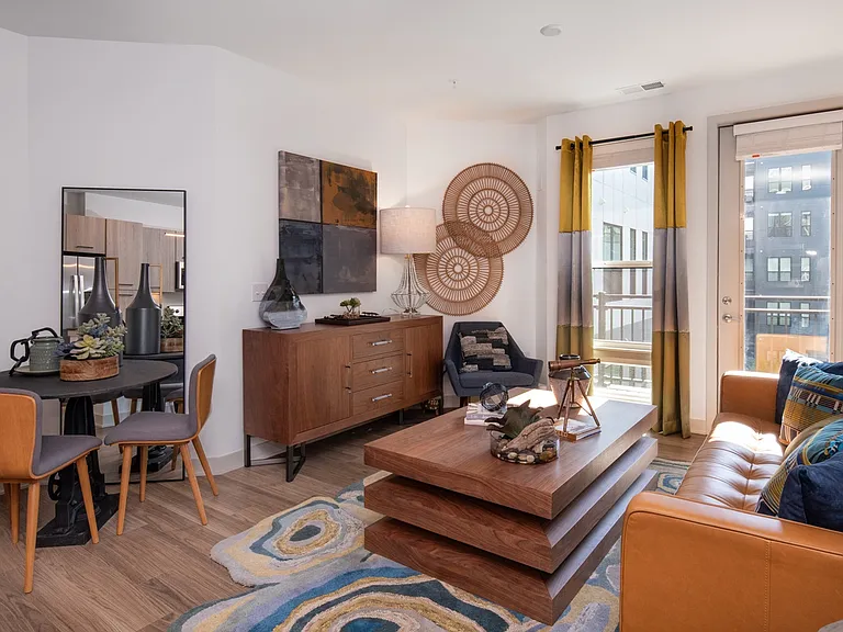 Stylish living space with sunny windows and warm modern decor.