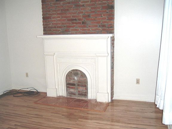 Living Room with Original Brick Wall and Mantle Feature