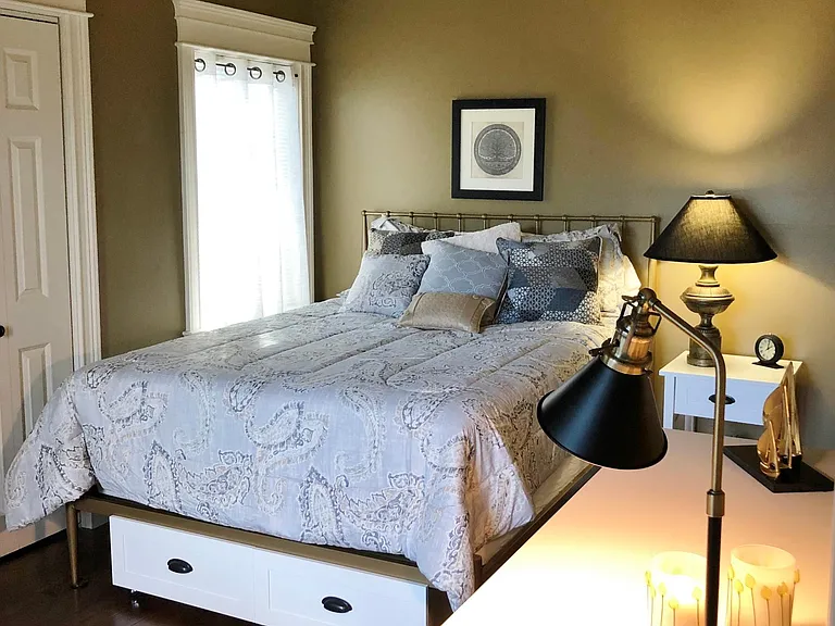 Queen bedroom #1 with sliding doors to a 2nd deck overlooking marsh. This comfortable chic bedroom has a private ensuite bathroom and the closet has shelf baskets with hanging storage.