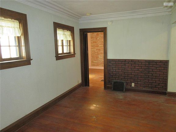 Take a peek at this charming den, originally the front room of the house. Original hardwood floors and pretty ceiling molding accents.