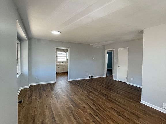 Living room with views of the kitchen and the hall to the bedrooms and bath.
