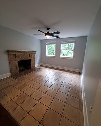 Tiled family room with decorative fireplace. Can also serve as TV room, play room or office.