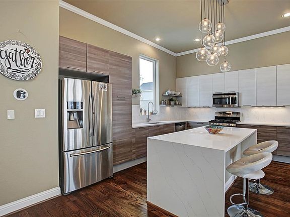 Contemporary kitchen with quartz counters and decorative back-splash is a chefâs dream with beautiful finishes and elegant lighting.
