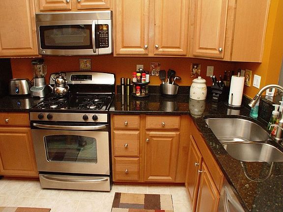 Another view of the kitchen work area with built-in microwave, dishwasher and butler's window to dining room.