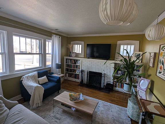 Living room with built in bookcases, aesthetic fireplace, large windows