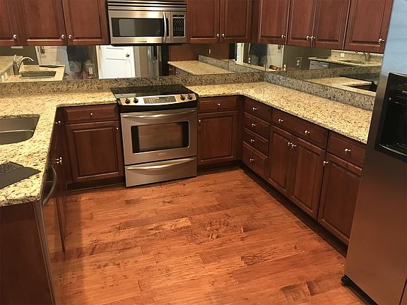 Stainless steel appliances and hardwood in the kitchen.