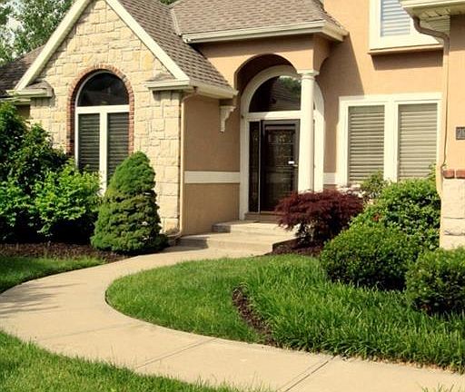 PLANTATION SHUTTERS ON FRONT WINDOWS - BRICK TRIM ON STONE & STUCCO FRONT