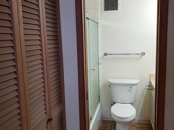 Hallway with lots of closet space leading to master bathroom