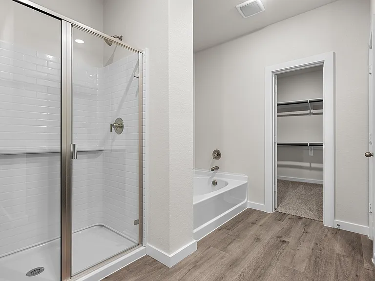 The master bathroom has a glass, walk-in shower and garden tub.