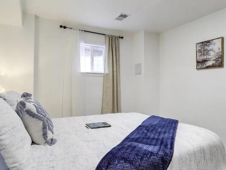 Well-kept bedroom with a comfortable bed, window with curtains, and simple wall art for an easy move-in setup.